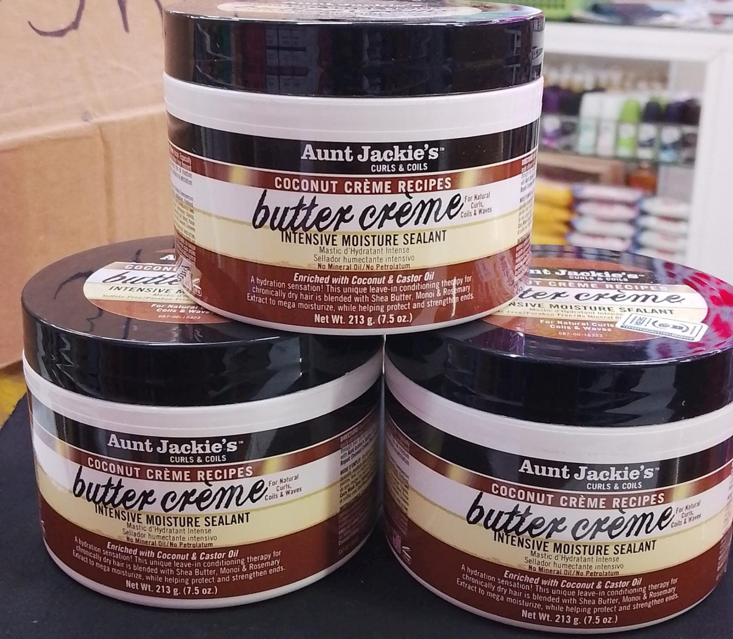 Three jars of Aunt Jackie's Butter Creme hair product on a shelf.
