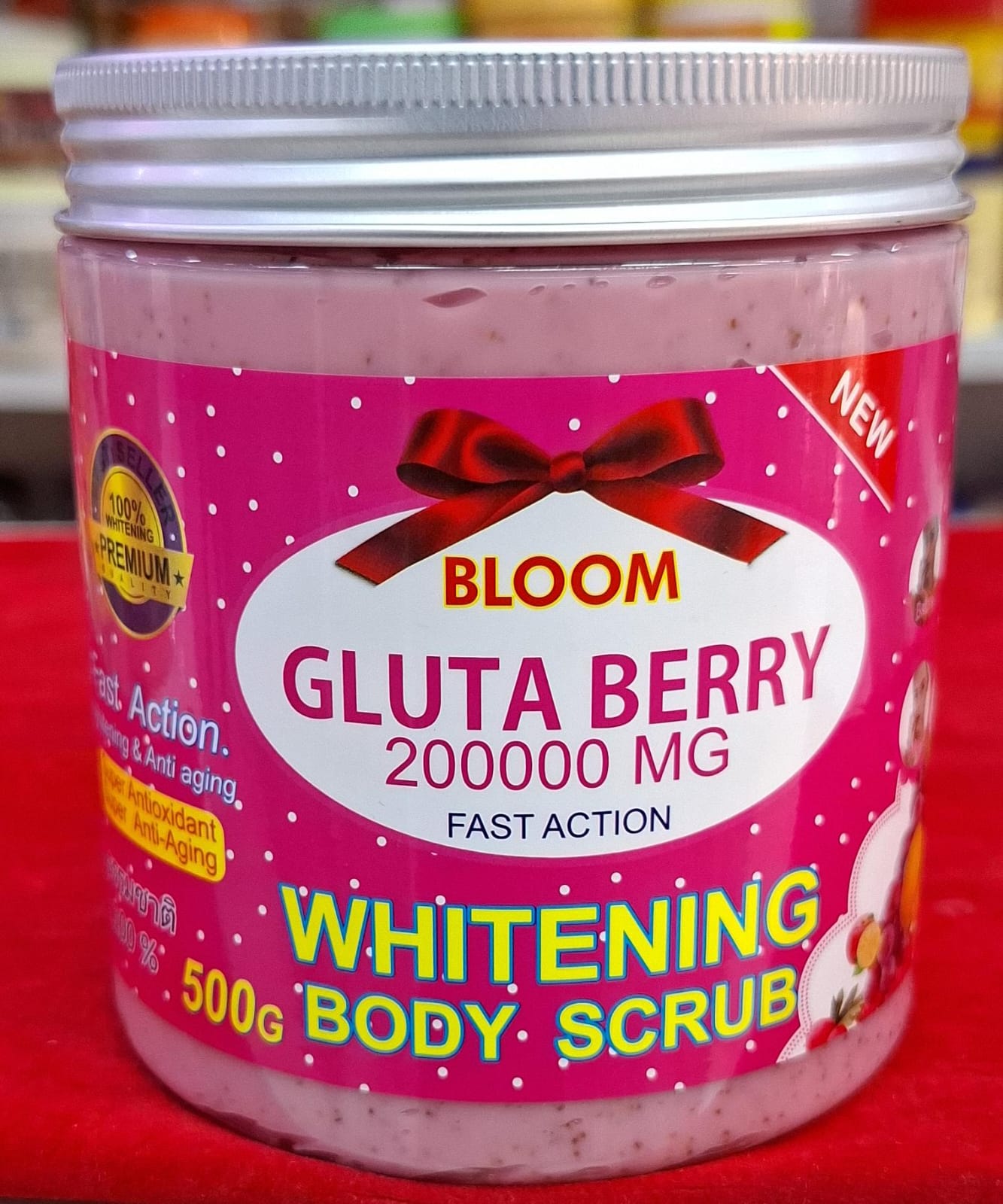 Jar of Bloom Gluta Berry Whitening Body Scrub on a red background