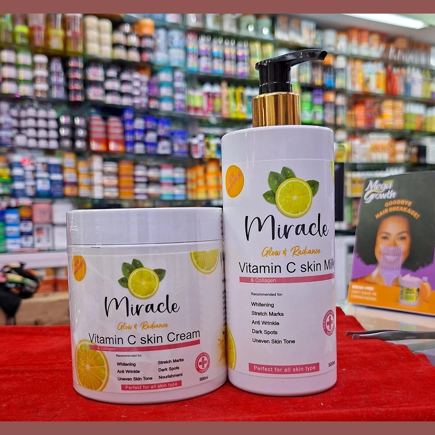 Two bottles of Miracle Vitamin C skincare products on a red surface with a store shelf in the background.