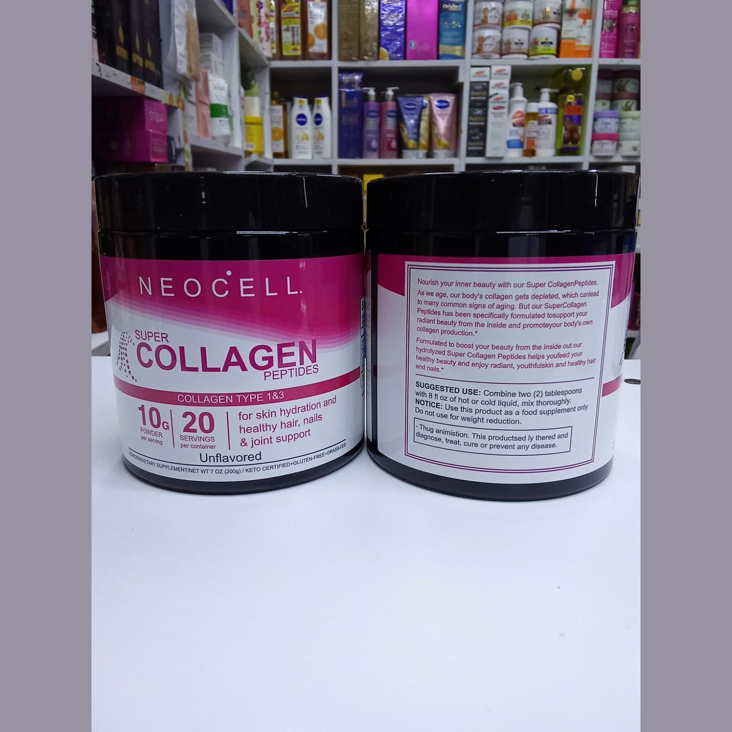 Two containers of Neocell Super Collagen Peptides on a white surface with a shelf of products in the background.