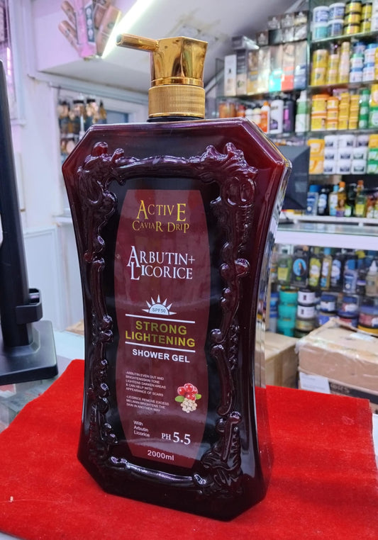 Bottle of Arbutin + Licorice shower gel on a red surface with a store shelf in the background.