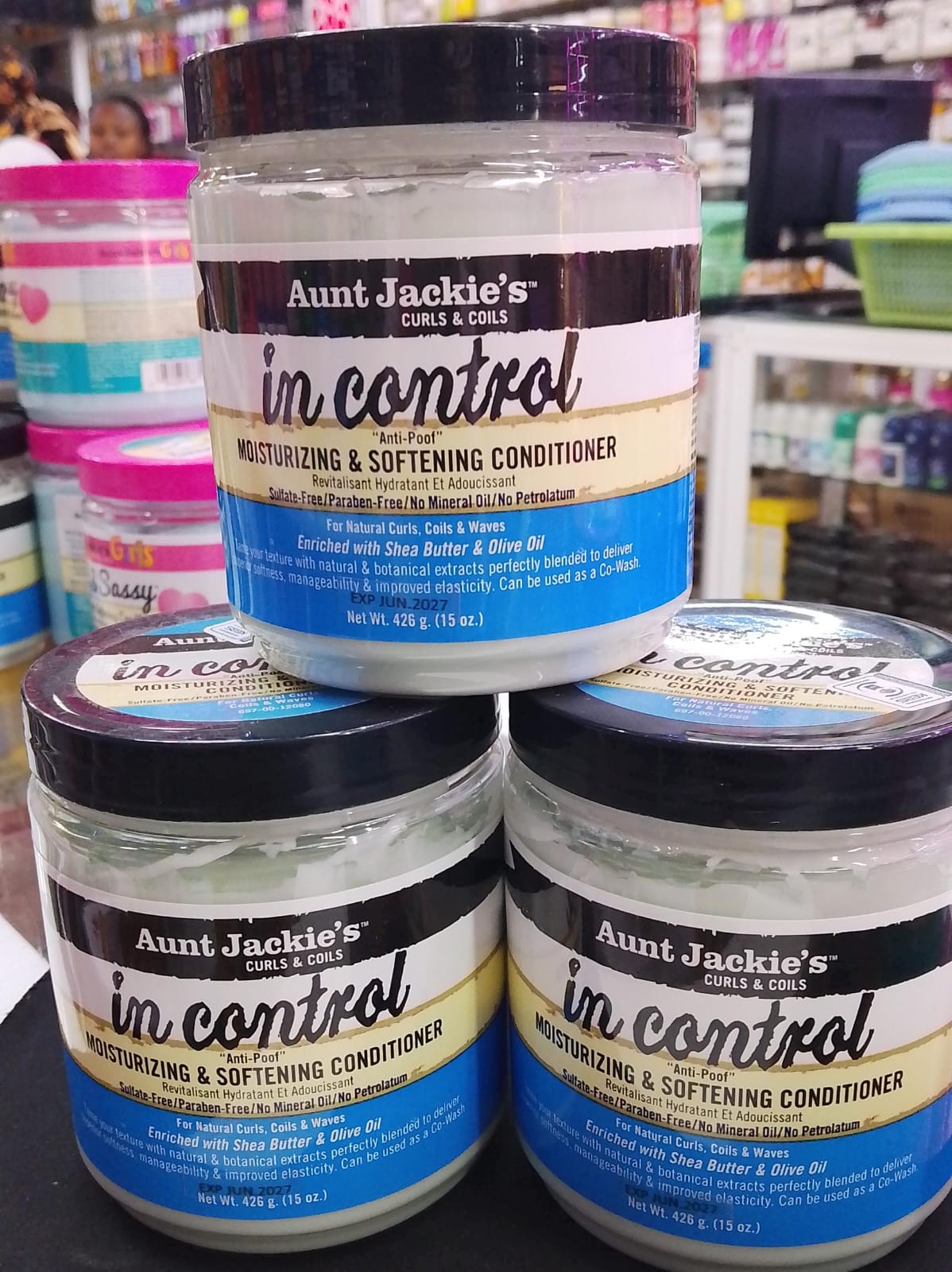 Three jars of Aunt Jackie's 'in control' conditioner stacked on a shelf.