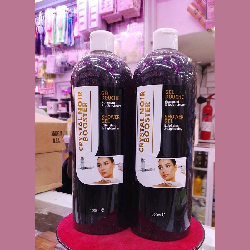 Two bottles of Crystal Noir Booster shower gel on a pink stand with a store background.