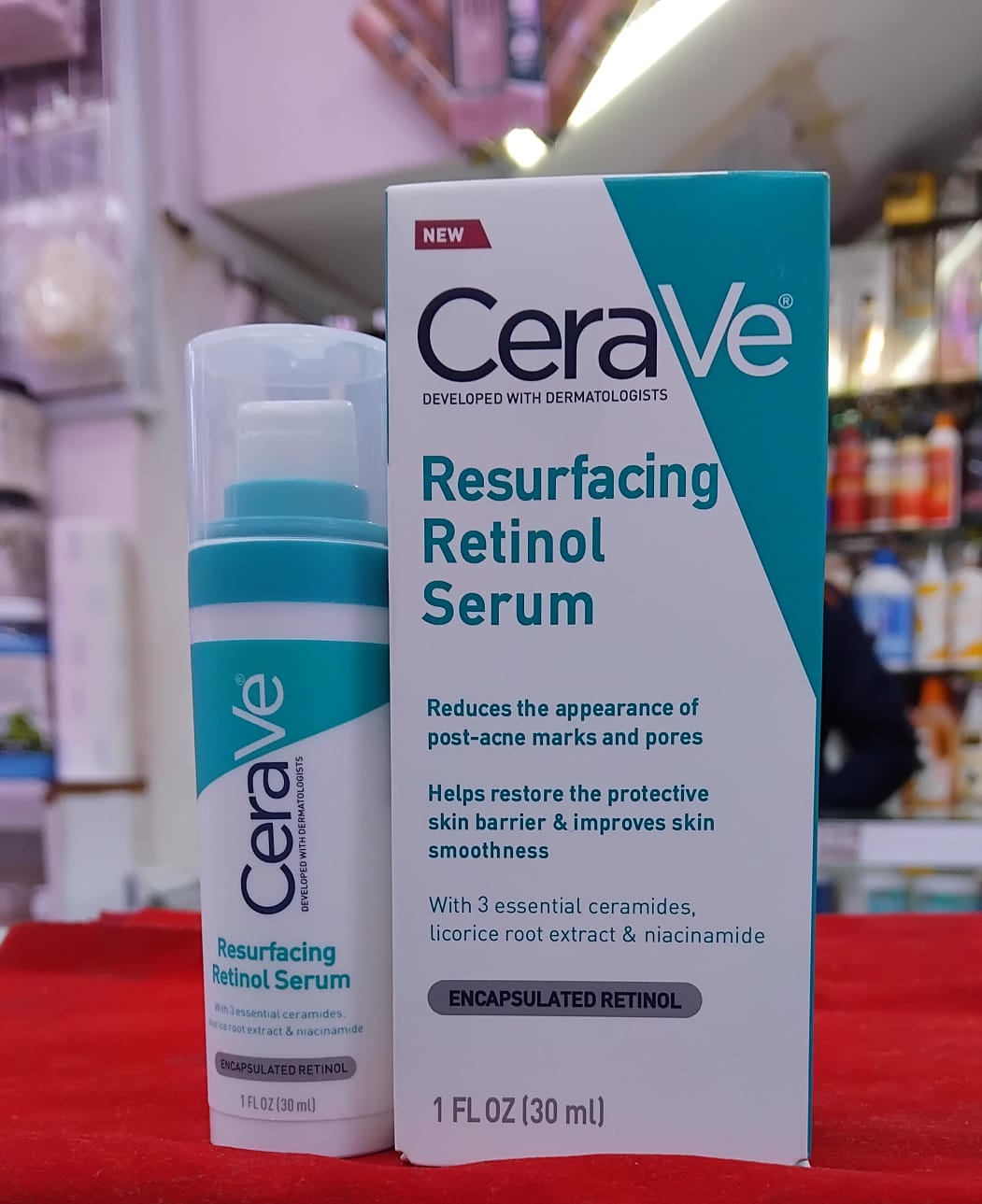 CeraVe Resurfacing Retinol Serum bottle and packaging on a red surface with blurred store background
