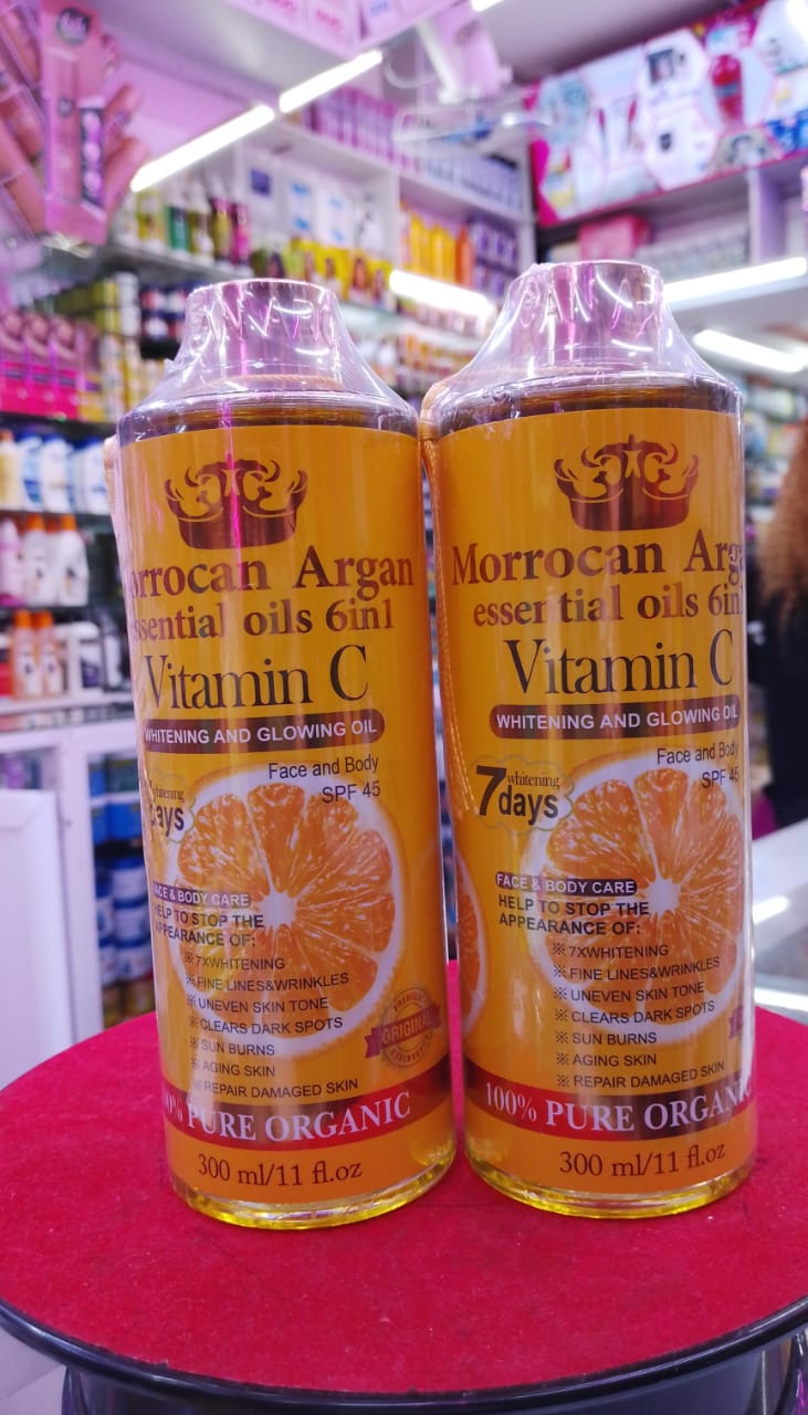Two bottles of Moroccan Argan Vitamin C oil on a counter with a store background.