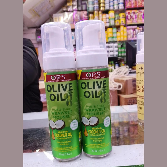 Two bottles of ORS Olive Oil Mousse with a store shelf in the background.