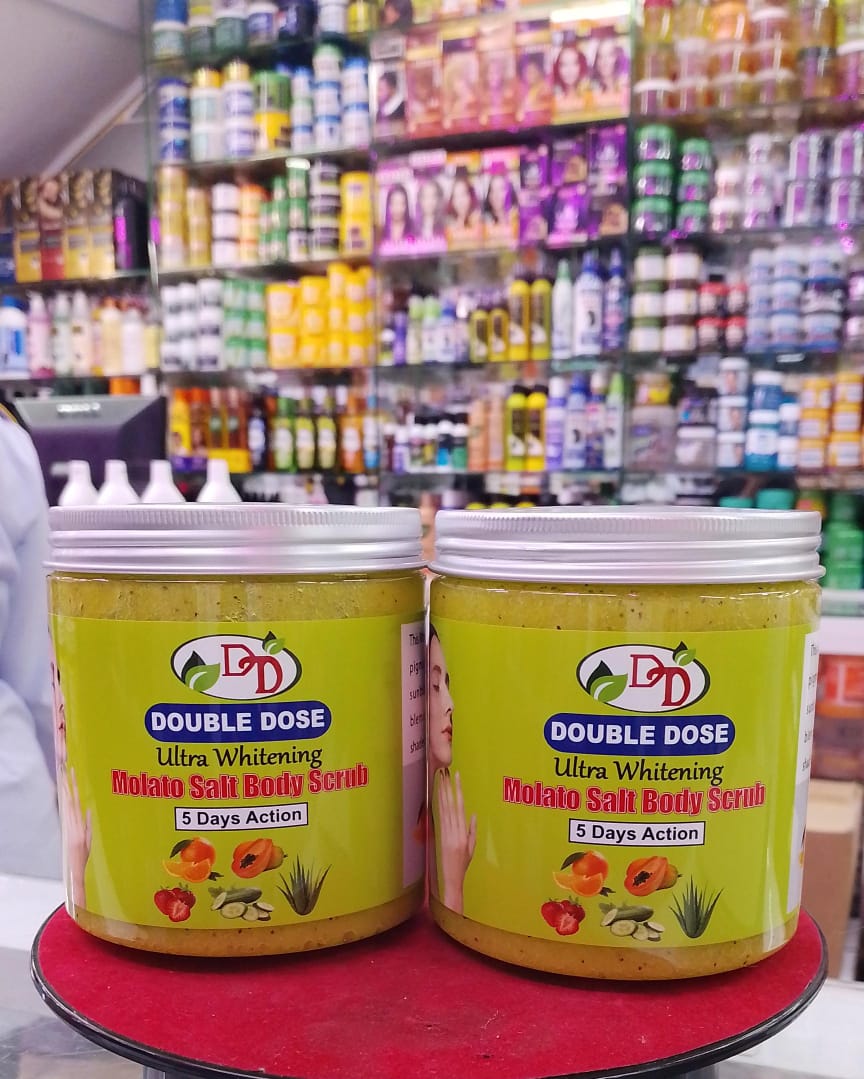 Two jars of Double Dose Potato Salt Body Scrub on a red surface with a store shelf in the background.