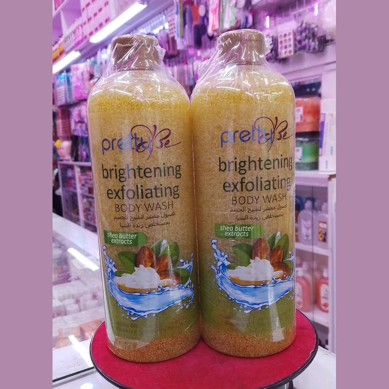 Two bottles of 'pretty be' brightening exfoliating body wash on a red surface with a store shelf in the background.