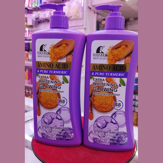 Two bottles of Roushun Amino Acid & Pure Turmeric Moisturizing Lotion on a red surface with a blurred background.