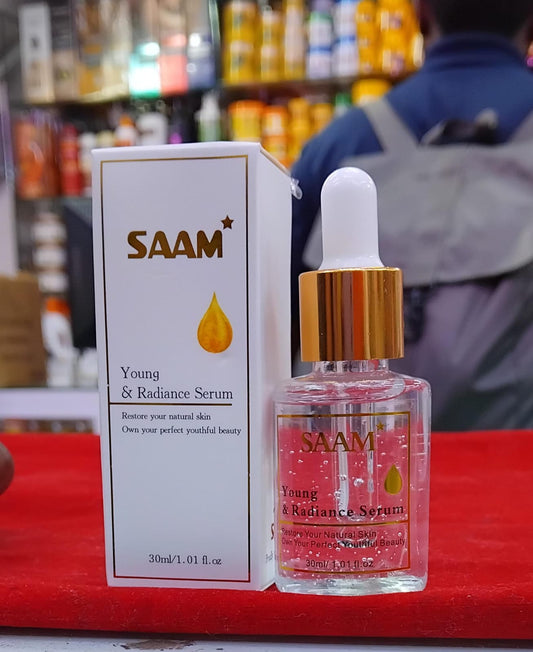 SAAM Young & Radiance Serum bottle and packaging on a red surface with blurred background