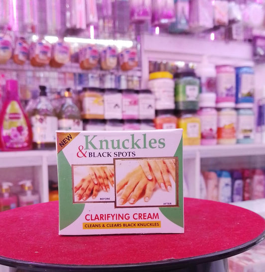 Knuckles and Black Spots clarifying cream packaging on a red surface with a blurred store background.