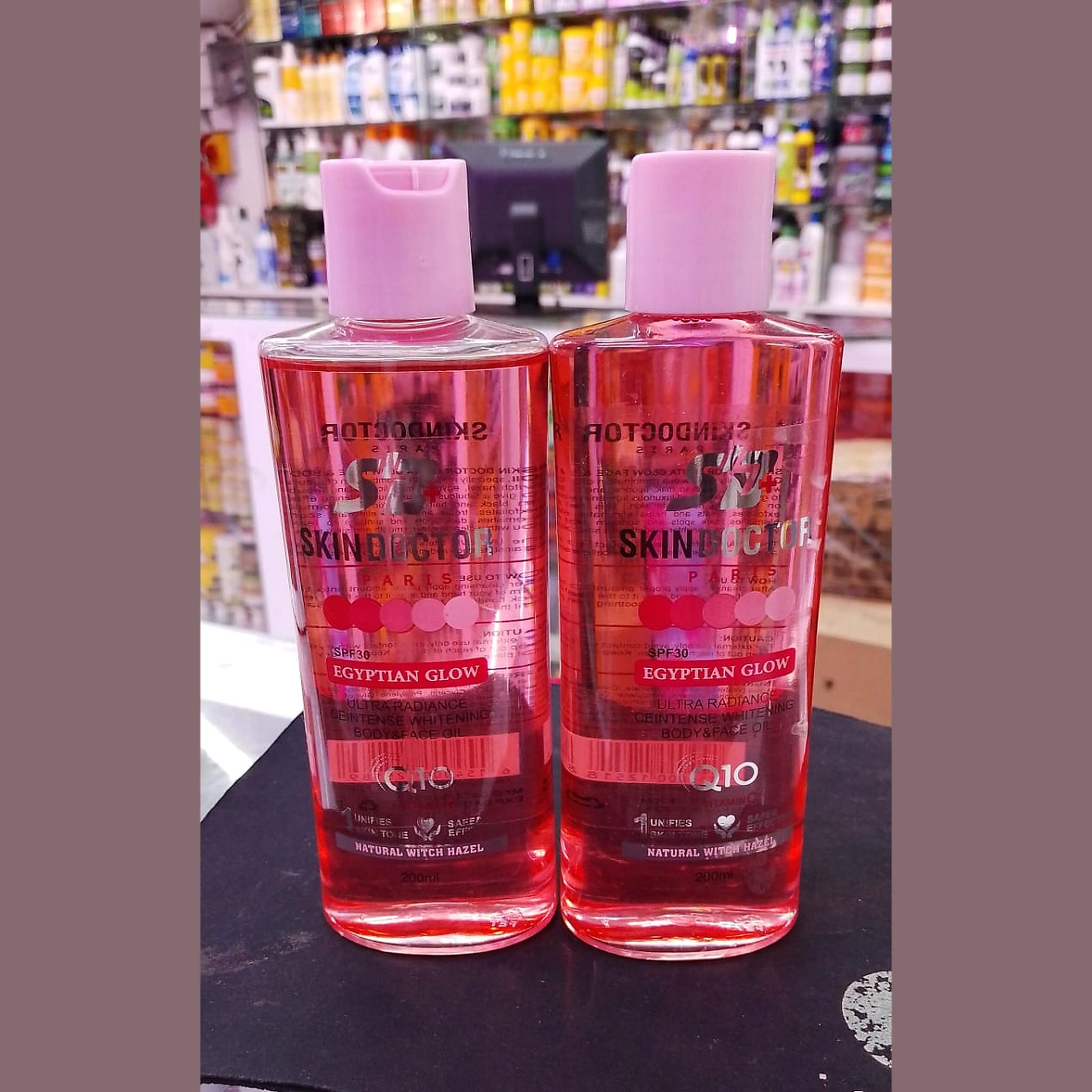Two bottles of Skin Doctor Egyptian Glow on a black surface with a store shelf in the background.