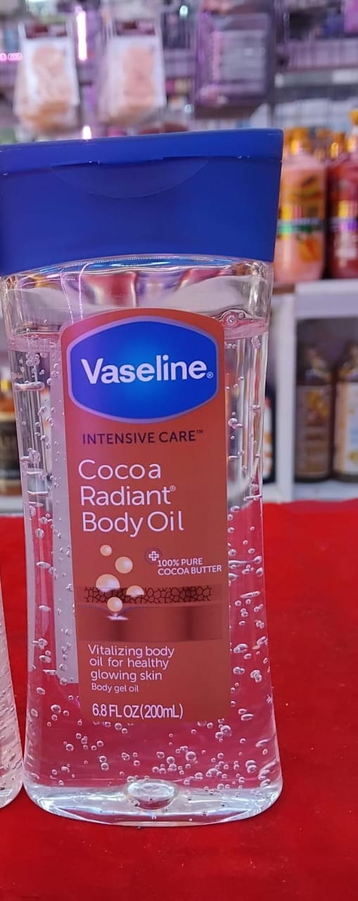 Vaseline Cocoa Radiant Body Oil bottle on a red surface with blurred store background