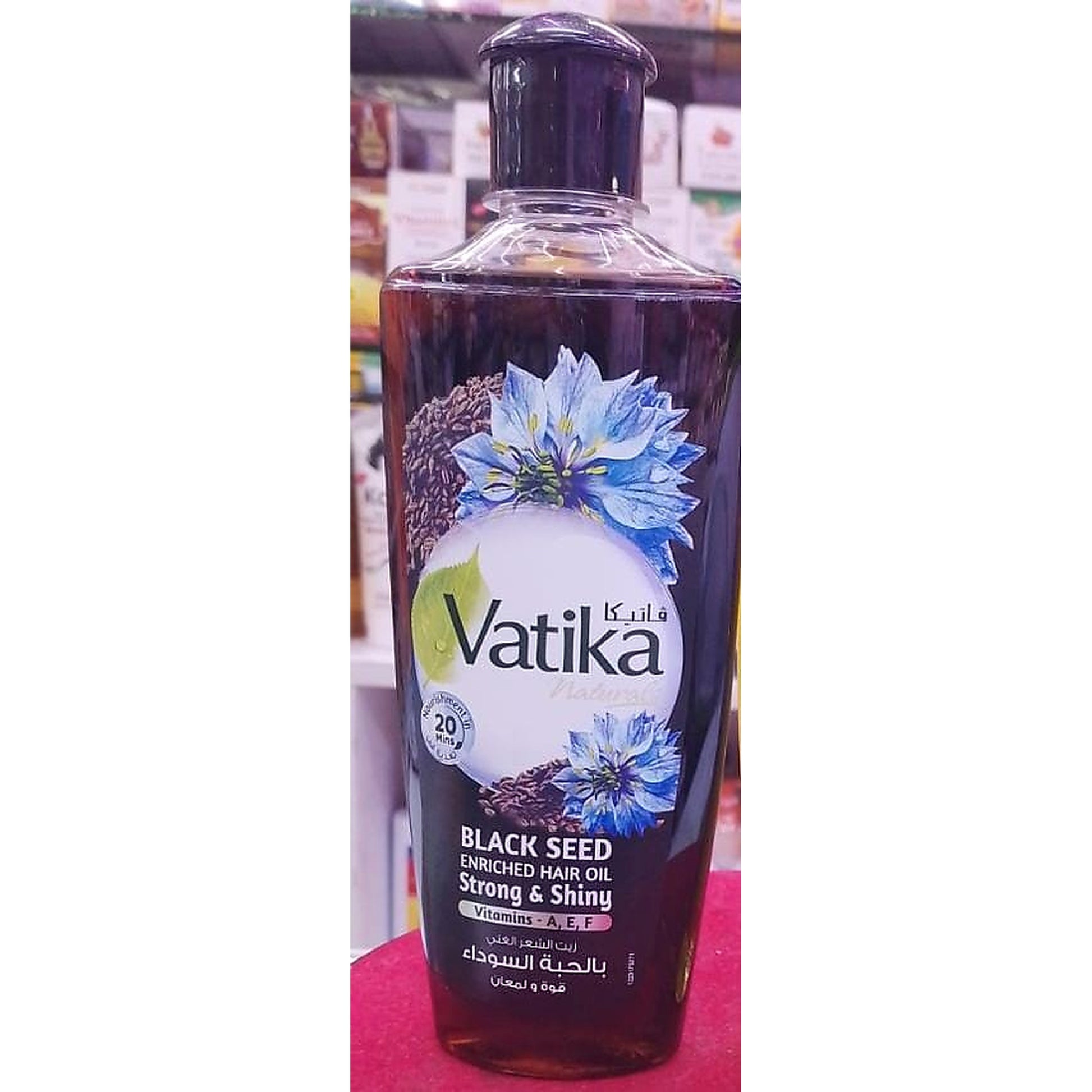 Vatika black seed enriched hair oil bottle with a blue flower design on the label.