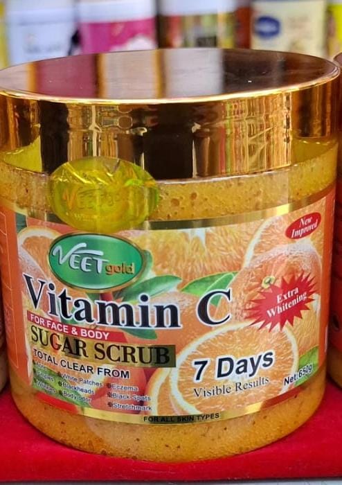 Neet Vitamin C sugar scrub jar with gold lid on a red surface