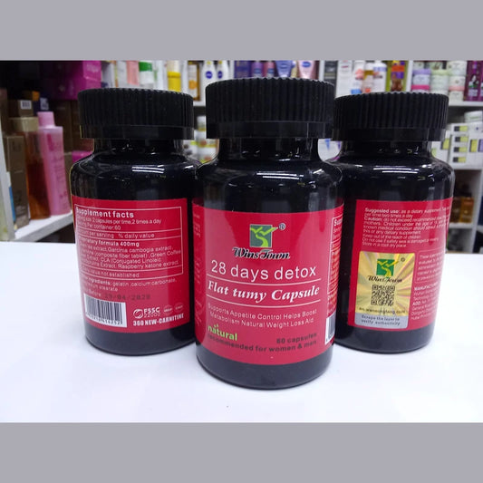 Three bottles of '28 days detox Flat tumy Capsule' on a white surface with a blurred background.