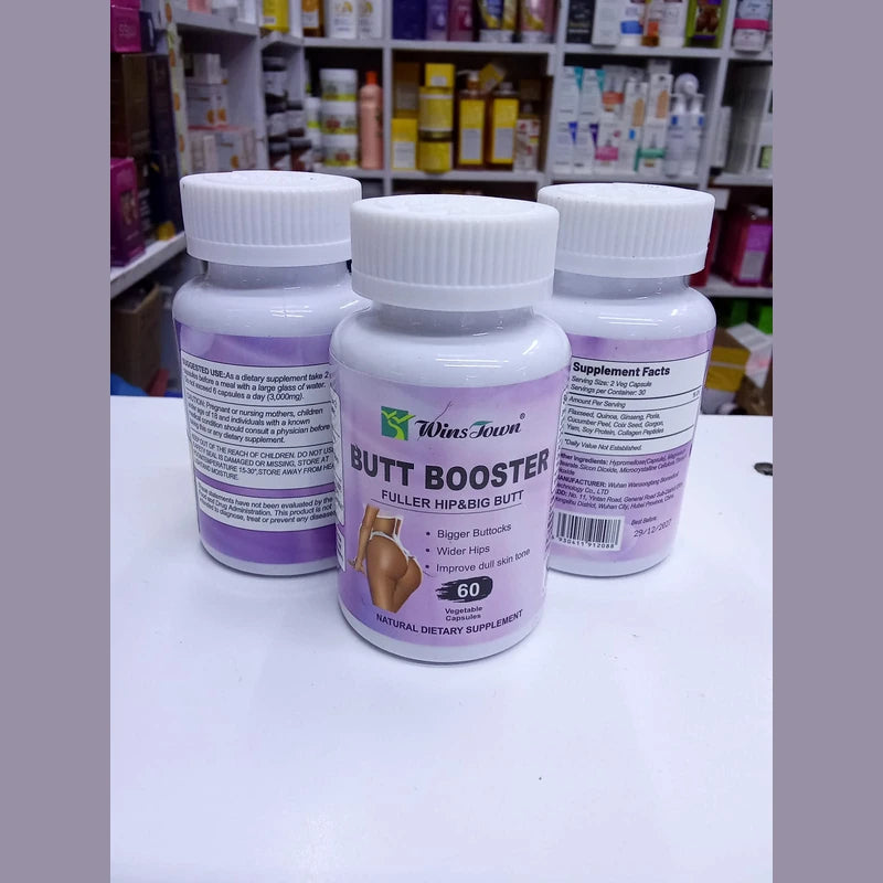 Three bottles of 'Butt Booster' supplements on a white surface with a store shelf in the background.