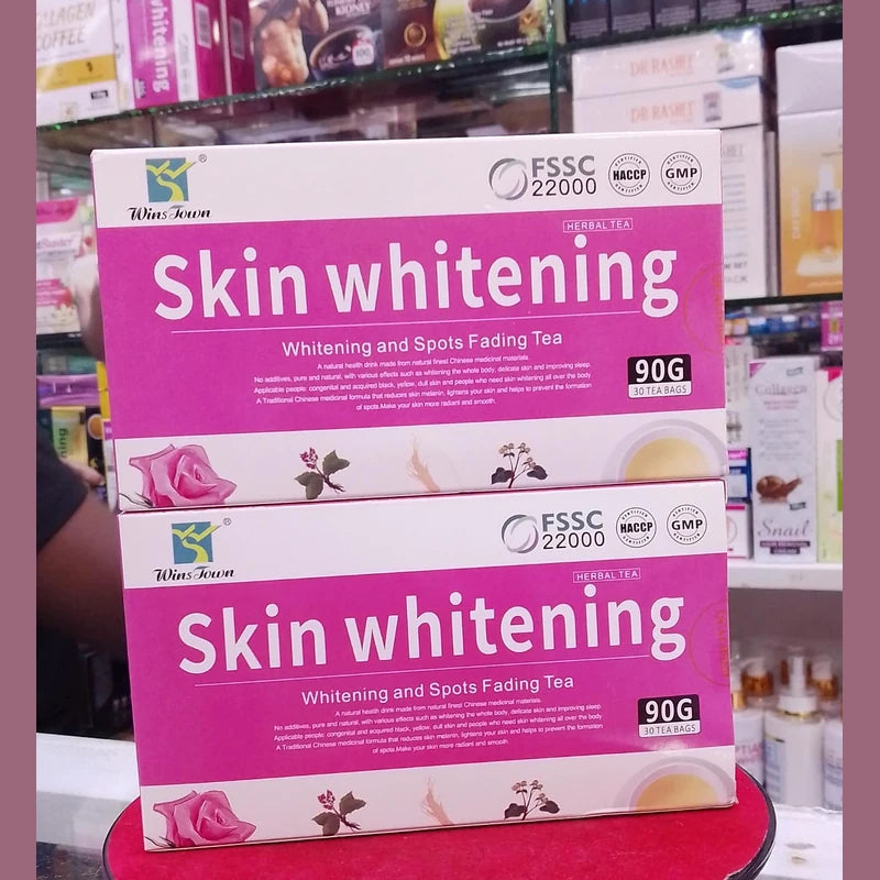 Two boxes of skin whitening tea on a shelf in a store.